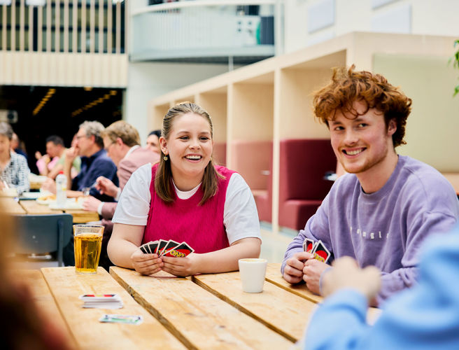 Studenten met kaartspel in atrium CHE