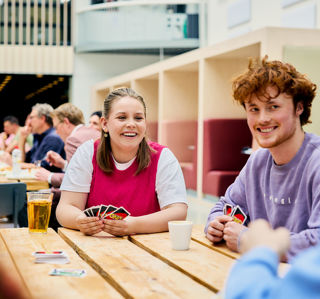 Studenten met kaartspel in atrium CHE