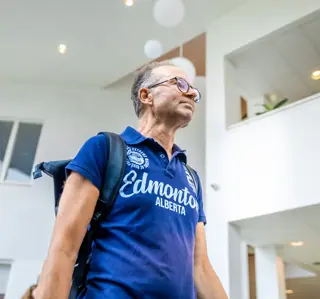Oudere man blauwe polo loopt in de ontvangsthal