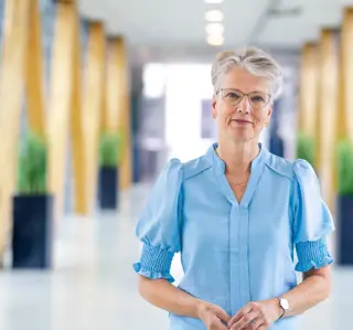 Vrouw op loopbrug grijs kort haar bril