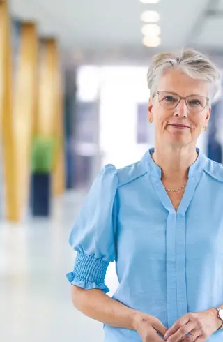 Vrouw op loopbrug grijs kort haar bril