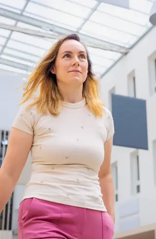 Jonge vrouw roze broek door atrium