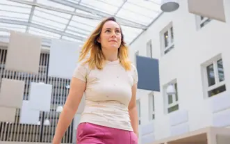 Jonge vrouw roze broek door atrium