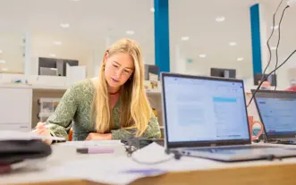 Jonge vrouw lang haar studerend in studiecentrum