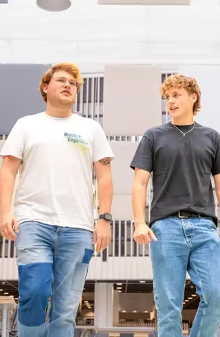 Twee blonde jongens lopend door atrium
