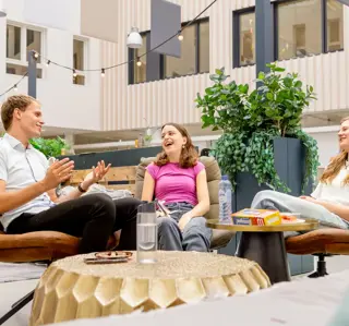 Lachende meiden plus jongen bij zithoek cheers