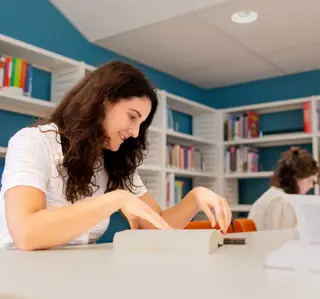 Jonge vrouw met krullen leest in studiecentrum