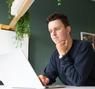 Mannelijke student achter laptop