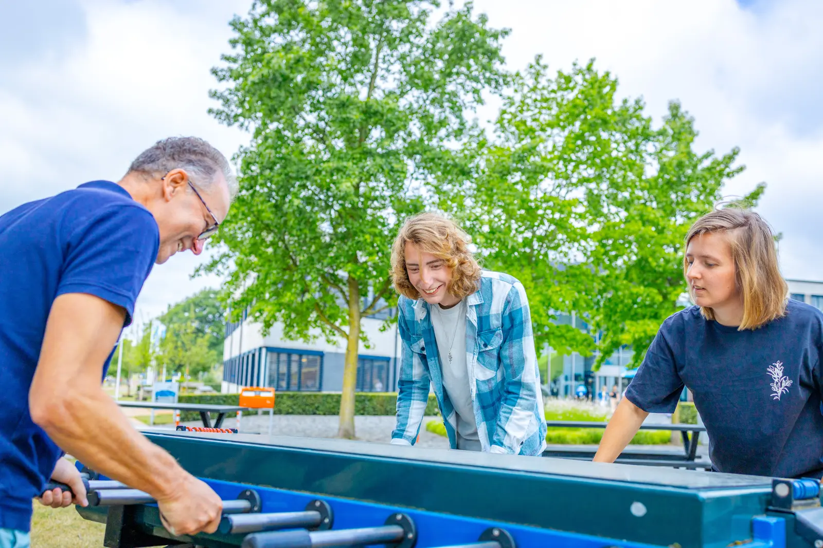 drie mensen bij tafelvoetbaltafel