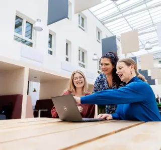 Drie dt vrouwen in atrium laptop